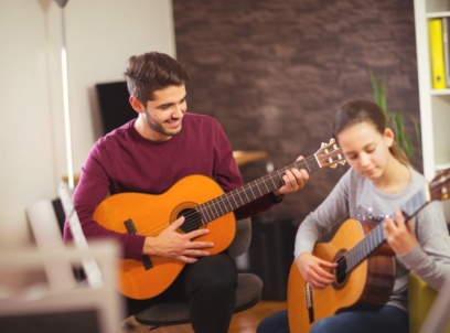 Music Teacher Teaching Student Guitar