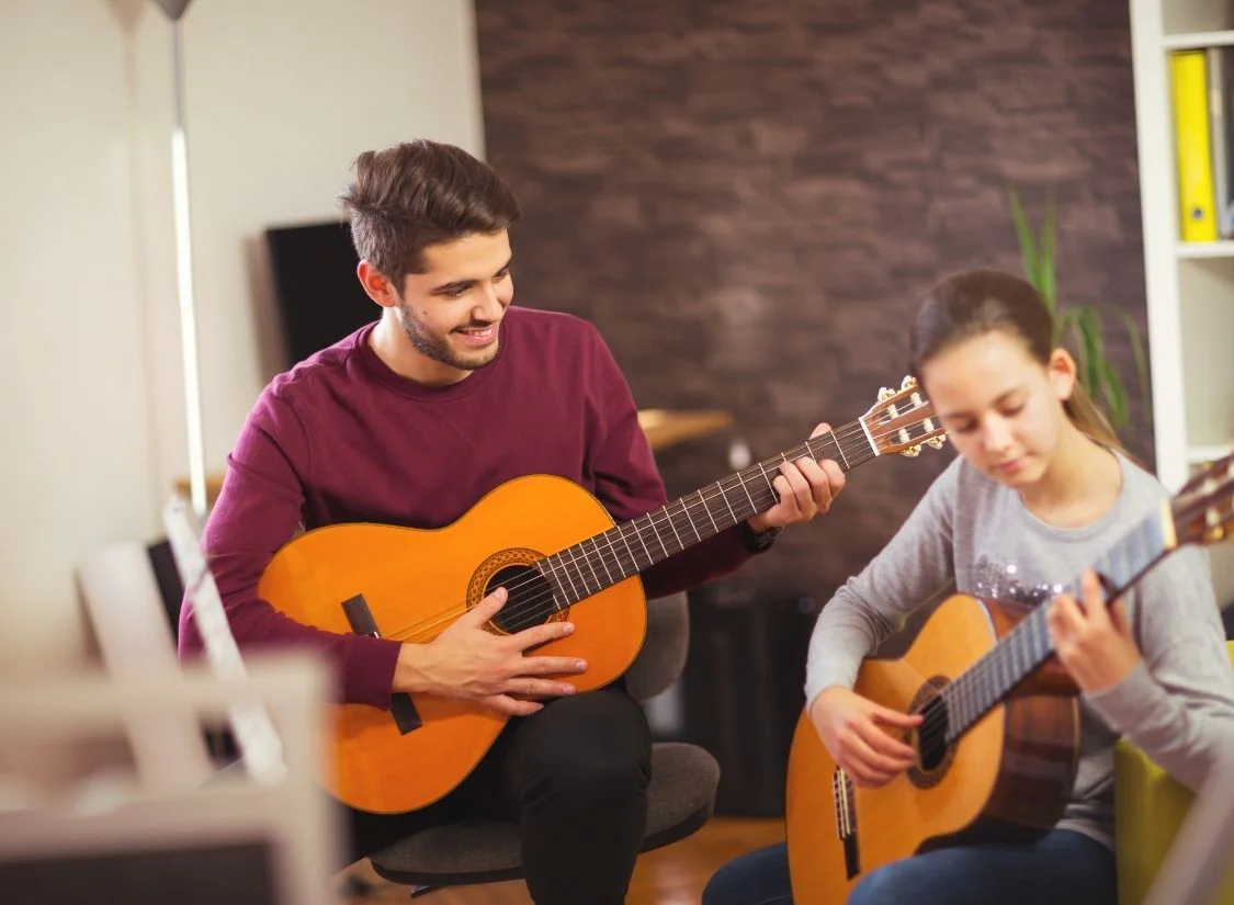 Music Teacher Teaching Student Guitar